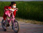 A girl wearing a face mask rides her bicycle  at a park after the lockdown was lifted in Wuhan, capital of Hubei province and China's epicentre of the novel coronavirus disease (COVID-19) outbreak, April 12, 2020. REUTERS/Aly Song