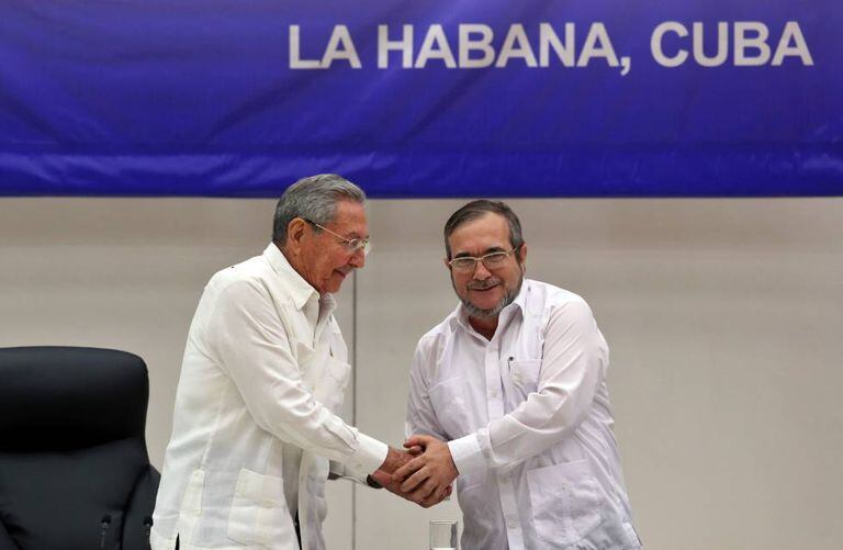 O líder das FARC, Rodrigo Londoño Echeverri, alias "Timochenko" (d), estreita a mão do presidente de Cuba, Raúl Castro.