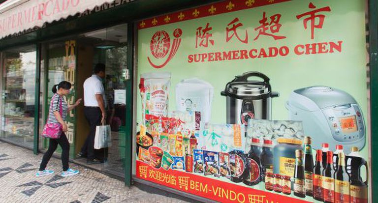 Consumidores entram em supermercado chinês em Lisboa.