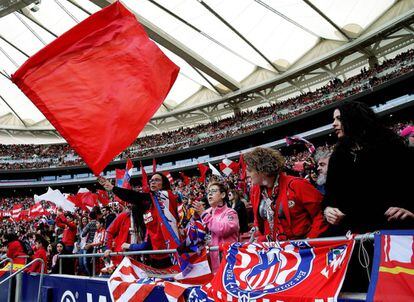 Torcedoras do Atlético de Madrid exibem bandeiras alvirrubras nas arquibancadas.