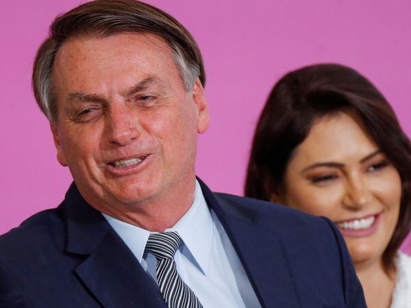 Brazil's President Jair Bolsonaro reacts next to his wife Michelle Bolsonaro during a ceremony marking International Women's Day at Planalto Palace in Brasilia, Brazil March 6, 2020. Picture taken March 6, 2020. REUTERS/Adriano Machado