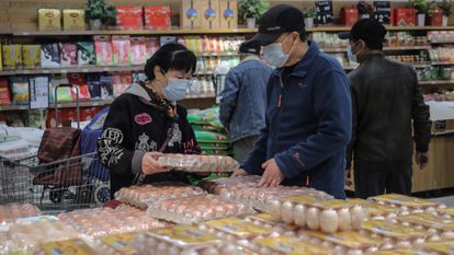 Várias pessoas compram em um supermercado de Pequim (China), nesta terça-feira.