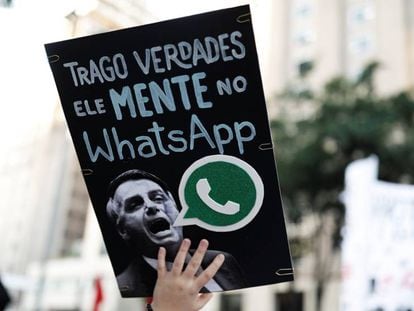 A woman holds a sign with the image of presidential candidate Jair Bolsonaro that reads 