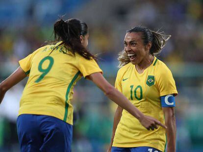 Marta e Andressa comemoram gol na estreia da seleção.
