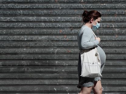 Uma mulher grávida caminha em Paris.