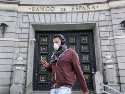 Pedestre caminha em frente ao Banco da Espanha, após o relaxamento das medidas de isolamento em Barcelona.