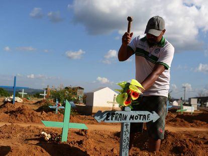 Familiar coloca cruz para identificar o túmulo de uma das vítimas da chacina em Altamira.