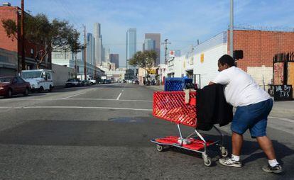 Uma mulher sem teto caminha pelas ruas do centro de Los Angeles.