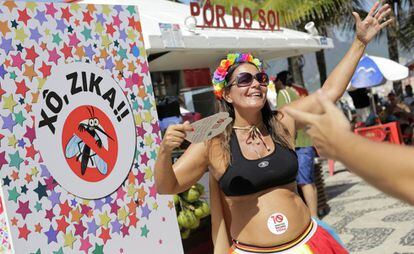 Uma grávida dança ao lado de cartaz contra o zika no Carnaval do Rio.
