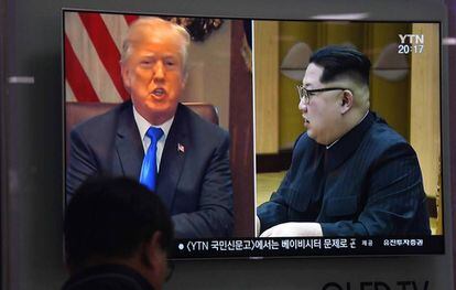 Um homem olha imagem de Trump e Kim na televisão.