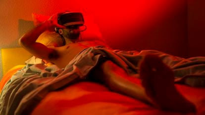 Um homem utiliza óculos de realidade virtual na cama.