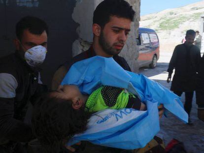 Homem carrega criança morta na terça-feira em Khan Sheikhoun.