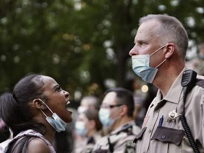Mulher repreende policial durante os protestos em Minneapolis.