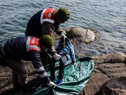 Policiais turcos colocam o corpo de uma criança morta por afogamento em uma bolsa na costa de Çanakkale.