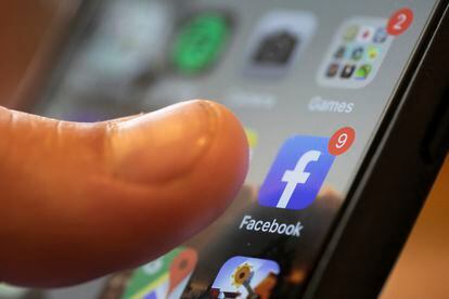 Homem usa o aplicativo do Facebook, que cancelou páginas e contas tidas como inautênticas.