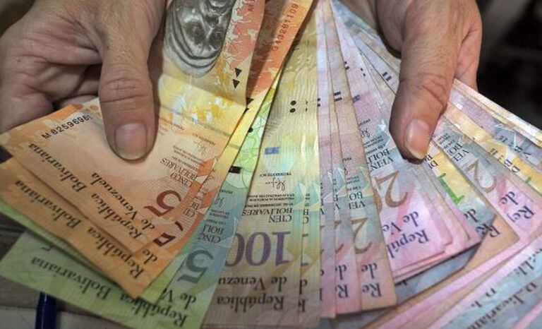 Vendedor conta notas de bolívar.