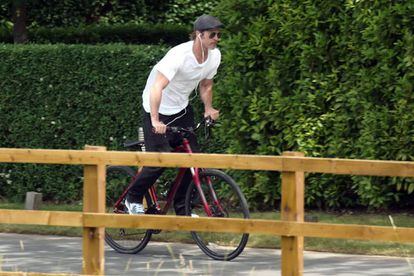 Brad Pitt andando de bicicleta em um parque em Londres.