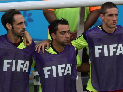 Xavi no banco de reservas junto a Juanfran e a Torres.