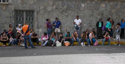 Um grupo de venezuelanos faz fila em frente a um supermercado de Caracas.