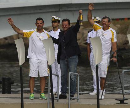 O prefeito Eduardo Paes recebe dos medalhistas olímpicos Torben (à esq.) e Lars Grael a tocha olímpica.