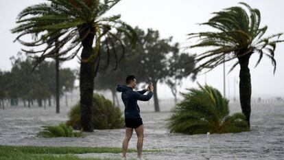 Un hombre toma fotos en el borde del lago Pontchartrain antes de la proximidad del huracán Ida en Nueva Orleans, el domingo 29 de agosto de 2021.