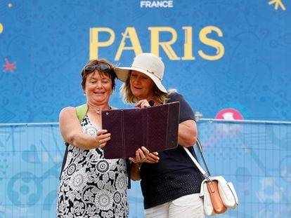 Turistas tiram selfie em frente a um cartaz publicitário de Paris, durante a final da Eurocopa, em 2016. 