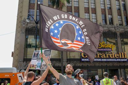 Manifestantes exibem bandeira da teoria da conspiração QAnon, em um protesto em 22 de agosto em Los Angeles.