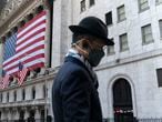 FILE - In this Nov. 16, 2020 file photo a man wearing a mask passes the New York Stock Exchange in New York. Stocks are opening lower on Wall Street again as Apple and other Big Tech companies give up more ground. The S&P 500 index fell 1.2% in the early going Tuesday, May 11, 2021.  (AP Photo/Mark Lennihan, File)