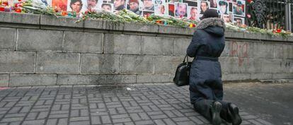 Uma mulher homenageia os mortos durante os protestos que derrubaram o presidente ucraniano, Víctor Yanukóvich.