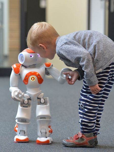Menino tenta se comunicar com o robô Neo.