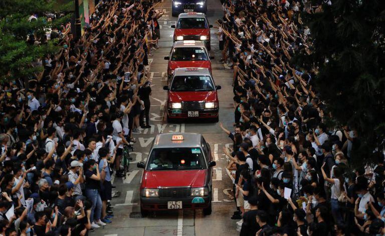 Manifestantes abrem espaço para táxis em Hong Kong durante um protesto em solidariedade ao estudante baleado pela polícia durante os distúrbios de 1º de outubro.