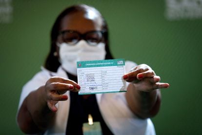 A enfermeira Mônica Calazans, primeira pessoa vacinada no Brasil, exibe sua caderneta de imunização.