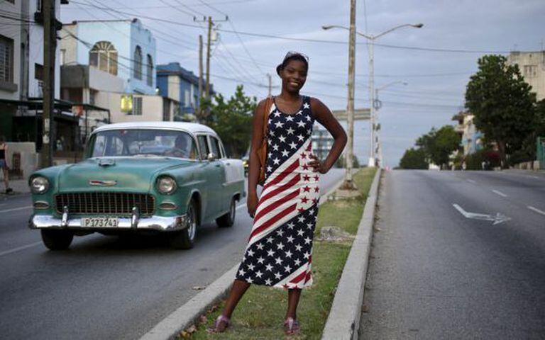 Jovem cubana vestida com a bandeira norte-americana em Havana.