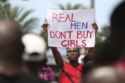 Um homem levanta um cartaz onde se lê "os homens de verdade não compram meninas", em um protesto em Lagos contra Boko Haram.