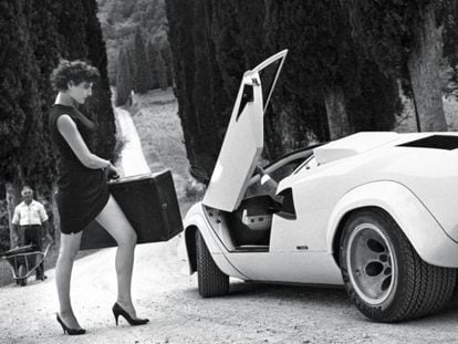 A modelo Antonia Dell'Atte, com um vestido justo e sapatos de salto alto, se encaminha decidida para um carro esportivo