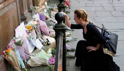 Uma mulher deposita flores pelas vítimas do atentado na Manchester Arena na terça-feira.