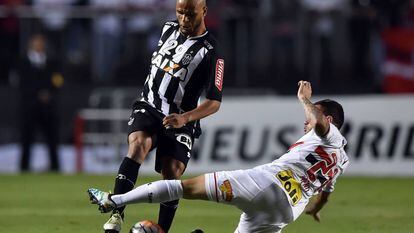 Patric (esq.) disputa a bola com Mena.
