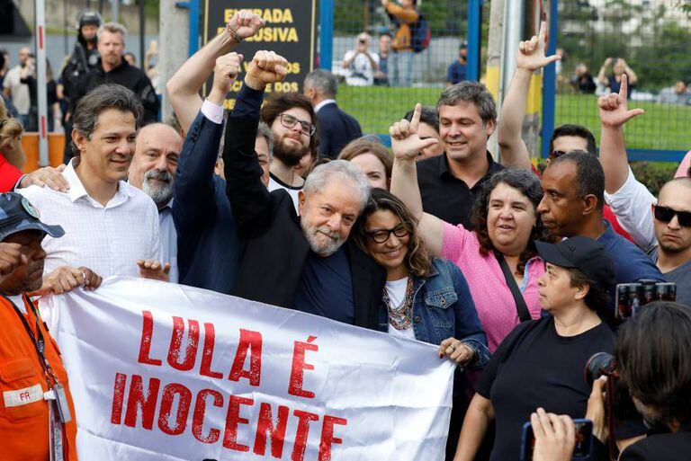 O ex-presidente Lula ao deixar a prisão em Curitiba, abraçado pela namorada e por apoiadores.