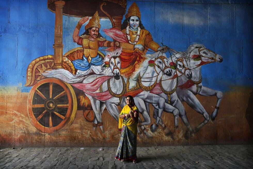 Uma eleitora, diante de um mural com uma cena do Mahabharata, em Uttar Pradesh.
