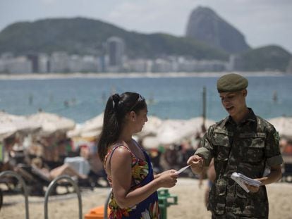 Soldado reparte panfletos informativos sobre o Zika em Copacabana.