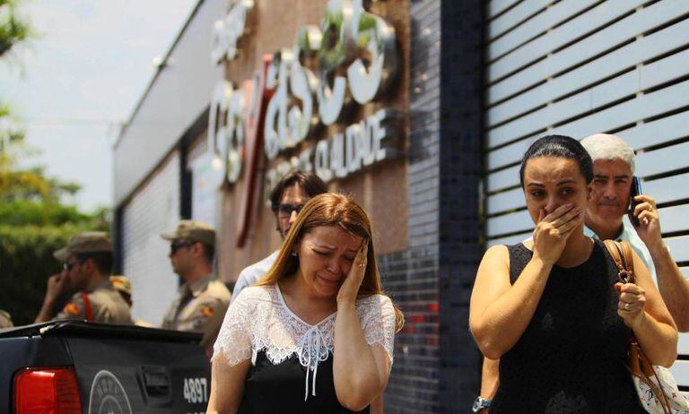 Pais de alunos diante do Colégio Goyases, ao fundo, policiais militares.