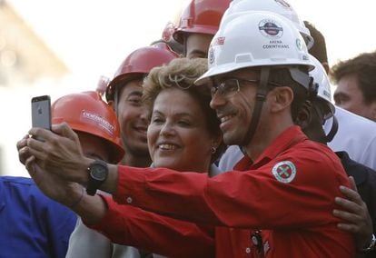 Dilma posa para fotos com trabalhador da Arena Corinthians.