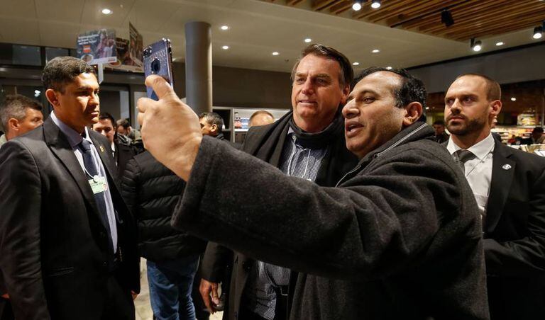 Homem tira foto com Bolsonaro em supermercado suíço.