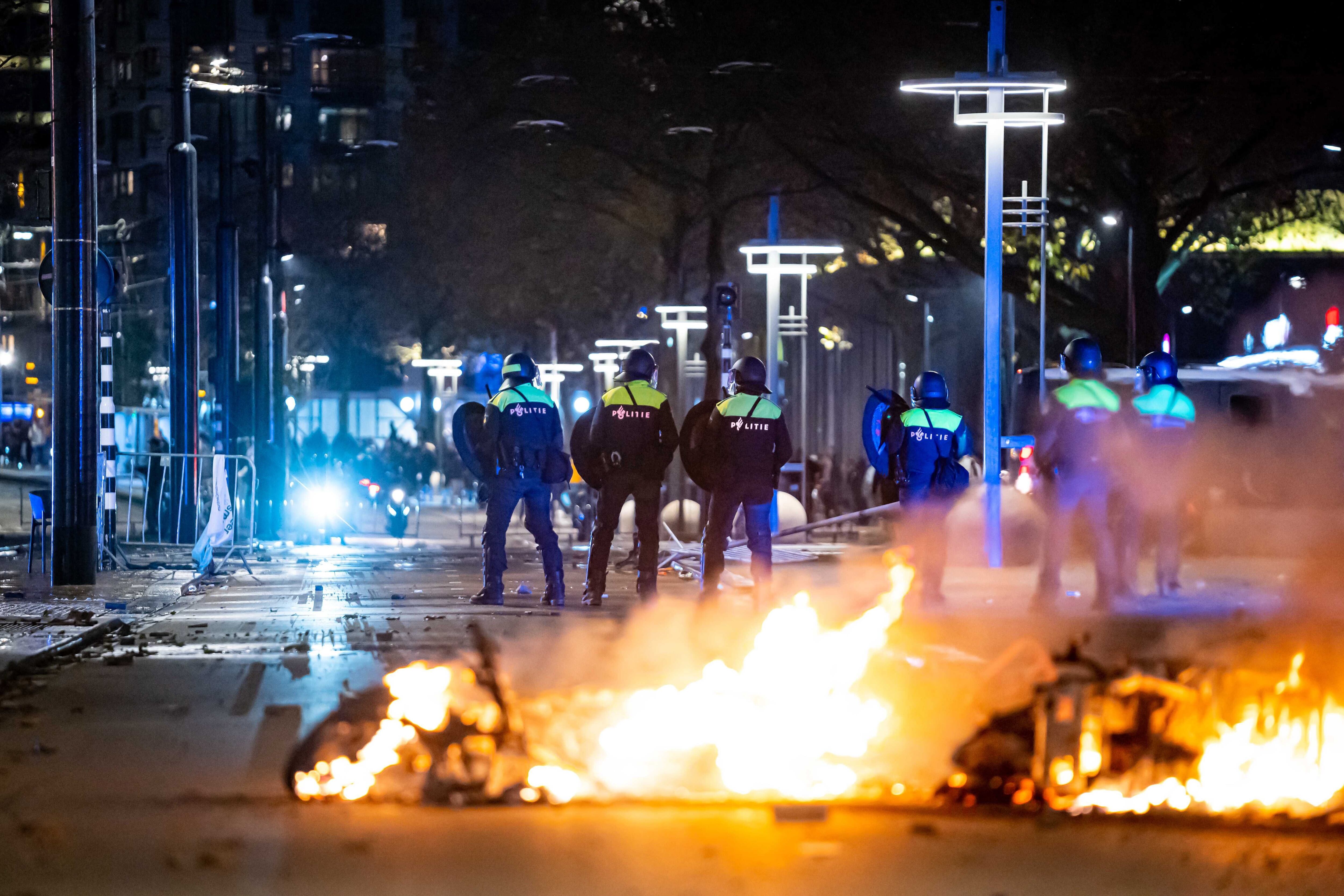 Policiais enfrentam manifestantes em uma rua de Roterdã na noite de sábado.