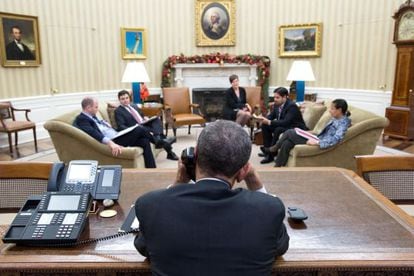 Barack Obama conversa por telefone com Raúl Castro no Salão Oval, na presença do Ben Rhodes e Ricardo Zúñiga, entre outros.