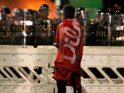 Manifestante pró-Dilma parado diante de um cordão de policiais em frente ao Congresso, onde grupos contrários ao impeachment protestaram.