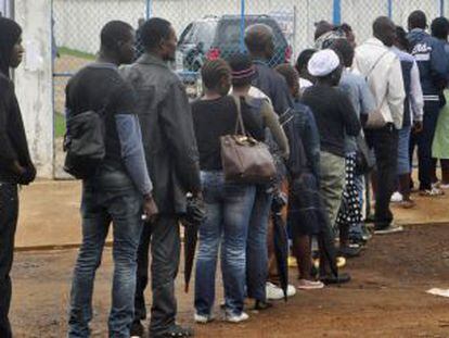 Trabalhadores da saúde da Libéria fazem fila para entrar em uma clínica de tratamento do ebola.