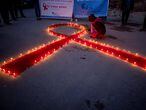 -FOTODELDÍA- EA1600. KATMANDÚ (NEPAL), 30/11/2020.- Mujeres y niños del orfanato de rehabilitación para aquellos que sufren de sida (VIH) 'Maiti Nepal', encienden varias velas de manera que forman un lazo rojo mientras rezan por aquellos que perecieron por este virus, este lunes en Katmandú (Nepal), en la víspera del Día Mundial de la Lucha contra el Sida. EFE/ Narendra Shrestha