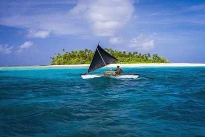 Embarcação tradicional em frente a um dos atóis da república insular de Kiribati, no oceano Pacífico.