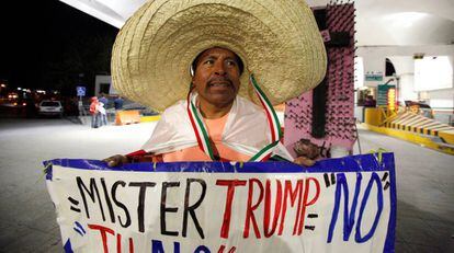 Martin Macias segura cartaz contra Trump em Ciudad Juarez, no México.
